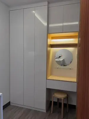 a room with white cabinets and a stool and a mirror at Staycation at JG in Manila
