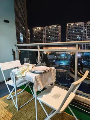 a table and chairs on a balcony with a city skyline at City Escape in Manila