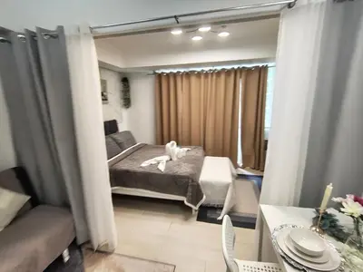 a bedroom with a bed with a white stuffed animal on it at City Escape in Manila