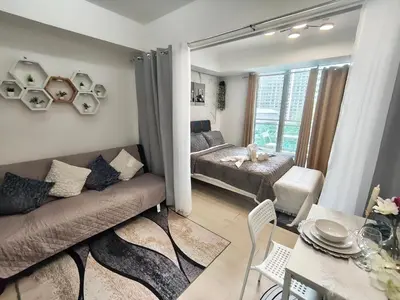a living room with a couch and a bed at City Escape in Manila