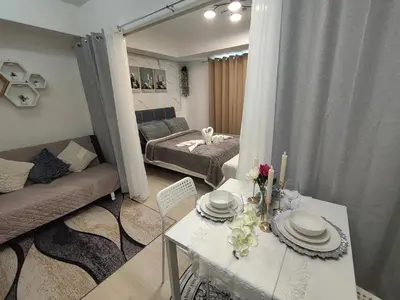 a living room with a table and a couch at City Escape in Manila