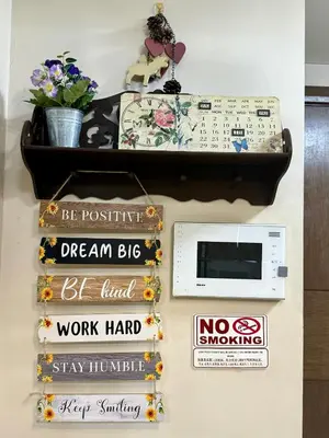 a shelf with books and a clock on a wall at One Palmtree Villas in Manila