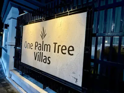 a sign that reads one rain tree villas at One Palmtree Villas in Manila