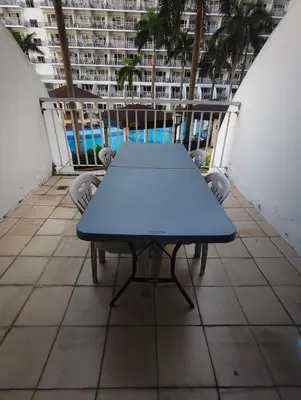 a blue table on the balcony of a building at Shell residences Moa Staycation by jeric in Manila