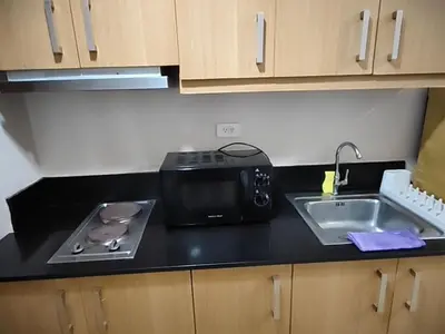 a kitchen counter with a toaster and a sink at Shell residences Moa Staycation by jeric in Manila
