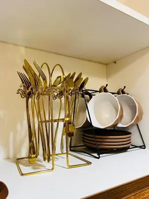 a shelf with plates and gold utensils on it at MOA GRAND STAY Suite #01, Newly Turn-over Only! in Manila
