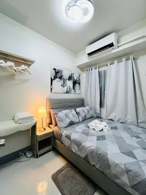 a bedroom with a bed and a desk and a tv at MOA GRAND STAY Suite 02 Newly Turn-over Only in Manila