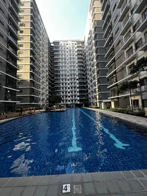 a large swimming pool in the middle of two tall buildings at MOA GRAND STAY Suite 02 Newly Turn-over Only in Manila