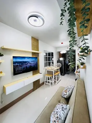 a living room with a couch and a tv on a wall at MOA GRAND STAY Suite 04 Newly Turn-over Only! in Manila