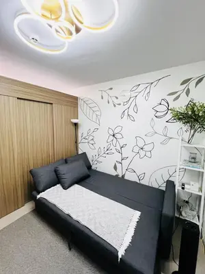 a bedroom with a bed with black and white flowers on the wall at MOA GRAND STAY Suite 03 Spacious Unit ! in Manila