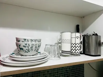 a counter with plates and cups on a shelf at MOA GRAND STAY Suite 03 Spacious Unit ! in Manila