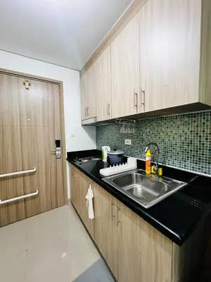 a kitchen with a sink and wooden cabinets at MOA GRAND STAY Suite 03 Spacious Unit ! in Manila