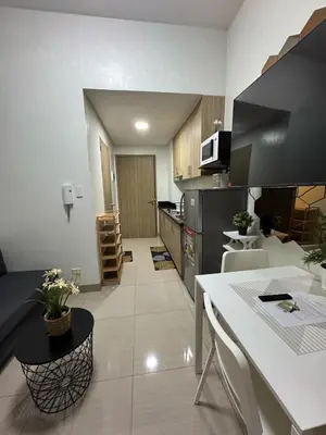 a kitchen with a table and a counter top at Staycation in Casitas in Manila