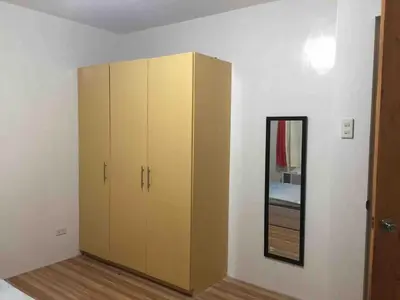 a large cabinet in a room with a mirror at Furnished 2BR Apartment in Paradahan