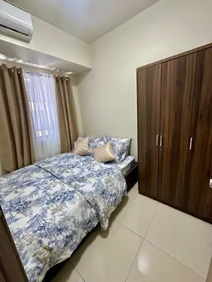 a bedroom with a bed and a wooden cabinet at Simple Stays at S Residence Pasay in Manila
