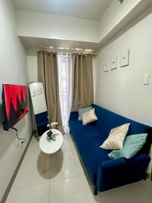 a living room with a blue couch and a table at Simple Stays at S Residence Pasay in Manila