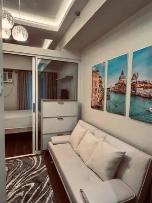 a living room with a white couch and some paintings at Staycation in Bloom in Manila