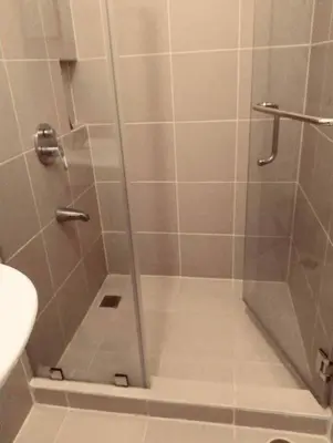 a shower with a glass door in a bathroom at Staycation in Bloom in Manila
