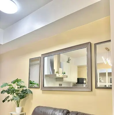 a living room with a couch and three mirrors at Staycation in Casa Joaquin in Manila
