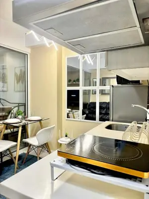 a kitchen with a sink and a table with chairs at Staycation in Casa Joaquin in Manila