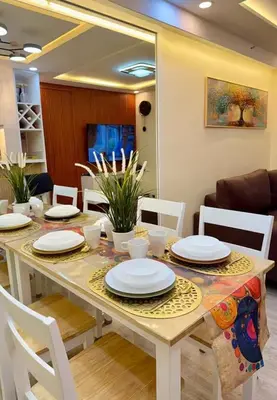a dining room table with white plates on it at Family Game Night 2BR PS4 Netflix Disney in Manila