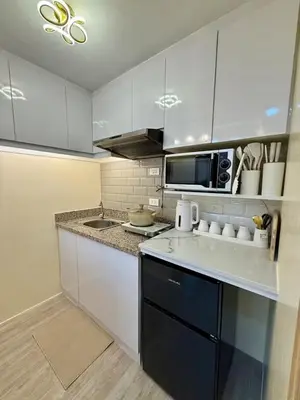 a kitchen with white cabinets and a counter top at Family Game Night 2BR PS4 Netflix Disney in Manila