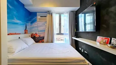 a bedroom with a bed with a painting on the wall at Czech Theme in Manila