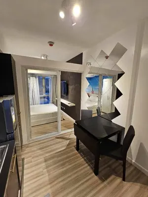 a living room with a black table and a bedroom at Czech Theme in Manila