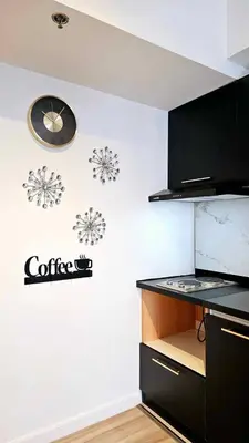 a kitchen with a coffee sign and a clock on the wall at Czech Theme in Manila