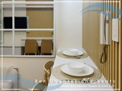 a kitchen with a table with two plates and an umbrella at GV Holiday Homes - Shore Residences MOA - Cozy 1BR Apartment in Manila