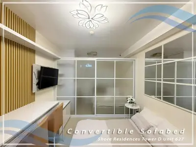 a living room with a tv and a room at GV Holiday Homes - Shore Residences MOA - Cozy 1BR Apartment in Manila