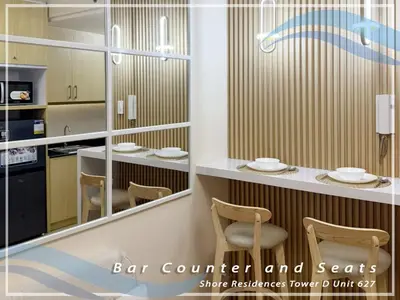 a restaurant with chairs and a counter with a mirror at GV Holiday Homes - Shore Residences MOA - Cozy 1BR Apartment in Manila