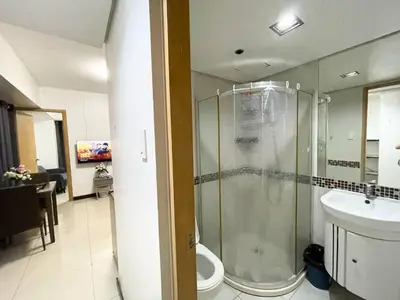 a bathroom with a shower and a toilet and a sink at Solemare parksuites tower C in Manila