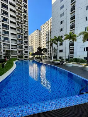 a large swimming pool in the middle of some buildings at Solemare parksuites tower C in Manila