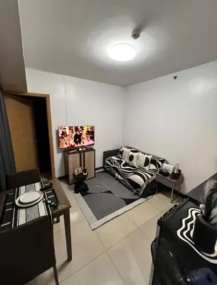 a living room with a couch and a tv at Solemare parksuites tower C in Manila