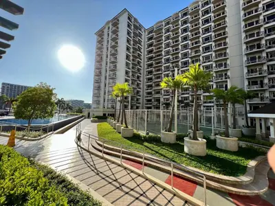 a building with palm trees in front of it at Solemare parksuites tower C in Manila