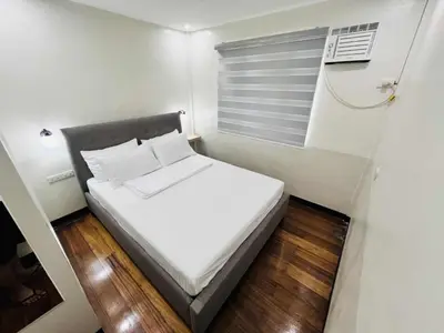 a small bedroom with a white bed and a window at Layover at 1146 in Manila