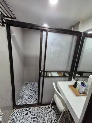 a bathroom with a shower with a table and chairs at Layover at 1146 in Manila