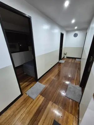 a living room with wood floors and a large mirror at Layover at 1146 in Manila