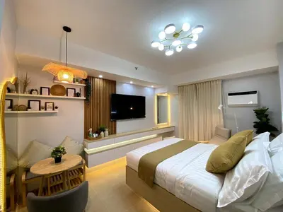 a bedroom with a bed and a television and a table at A Secret Space in Sucat Parañaque in Manila
