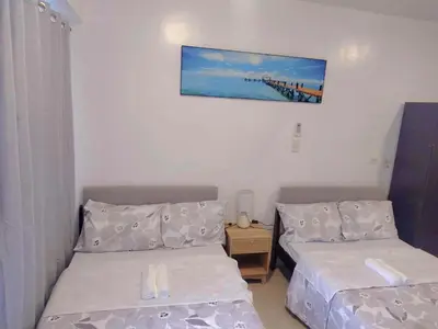 a room with two beds and a picture on the wall at Shorestandrelax in Manila