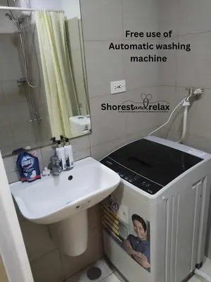 a bathroom with a white sink and a mirror at Shorestandrelax in Manila