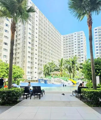 a resort with a swimming pool and palm trees at Shorestandrelax in Manila