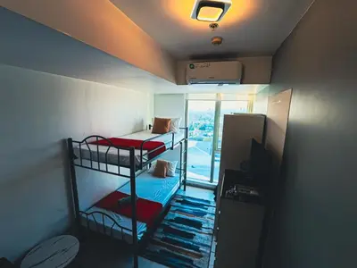 a small room with two bunk beds and a window at Celestial Shores Staycation at Azure Resort in Manila