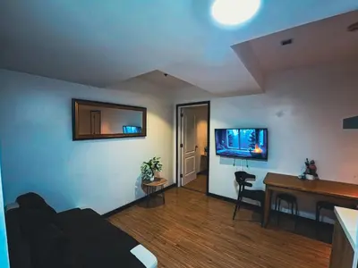 a living room with a desk and a tv on the wall at Celestial Shores Staycation at Azure Resort in Manila