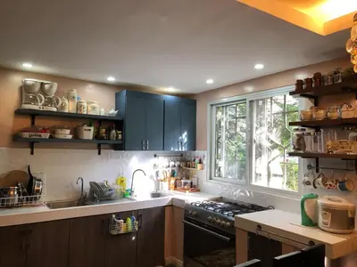 a kitchen with blue cabinets and a stove and a window at Our home is your castle in Caong