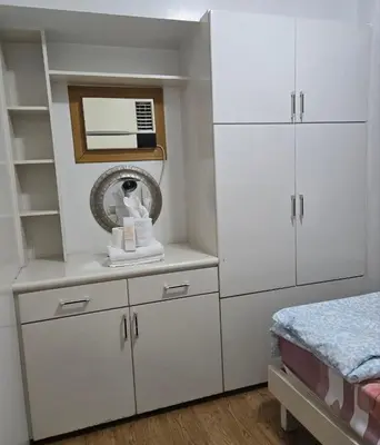 a white bedroom with white cabinets and a mirror at Sea Residence - 2 Bedrooms - 5 mins walk to MOA 1A in Manila