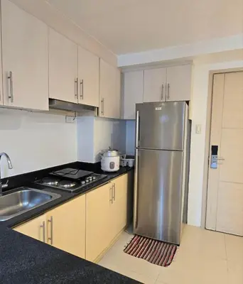 a kitchen with a stainless steel refrigerator and a sink at Sea Residence - 2 Bedrooms - 5 mins walk to MOA 1A in Manila