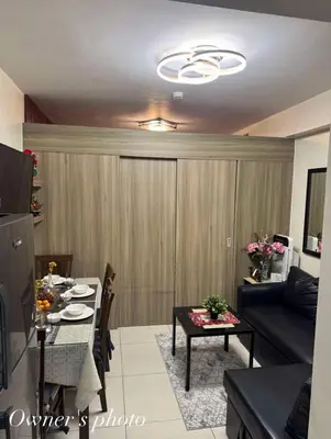 a living room with a table and a couch at Juvrey Studio-Unit Breeze Residences in Manila