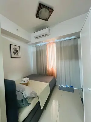 a small bedroom with a bed and a window at Allie's Cozy Place in Manila